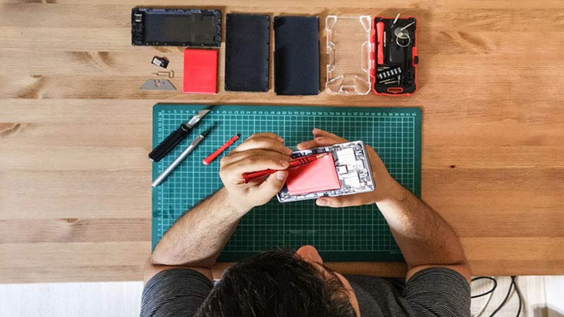 Een man repareert een smartphone.